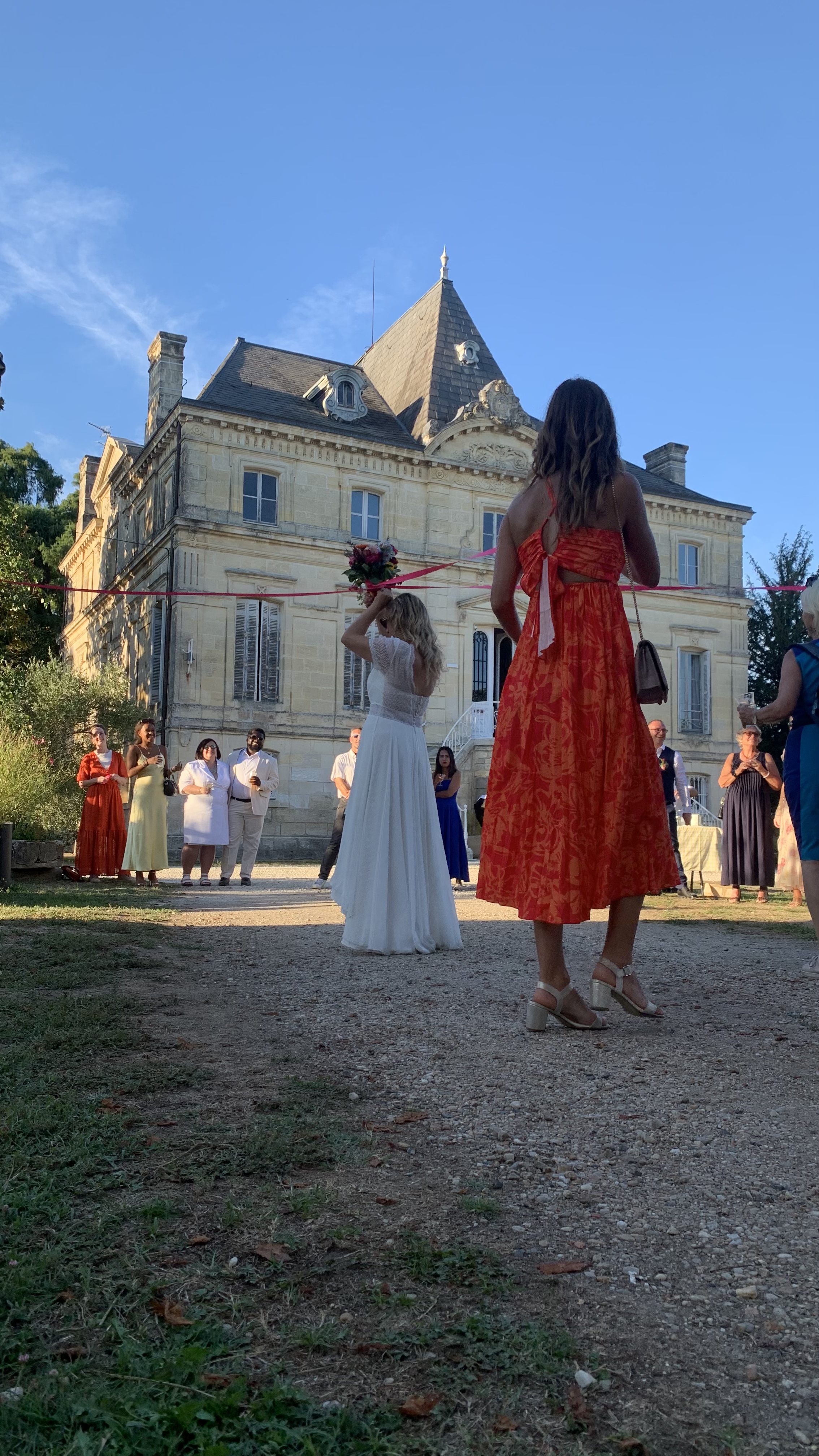 Bouquet toss in front of château